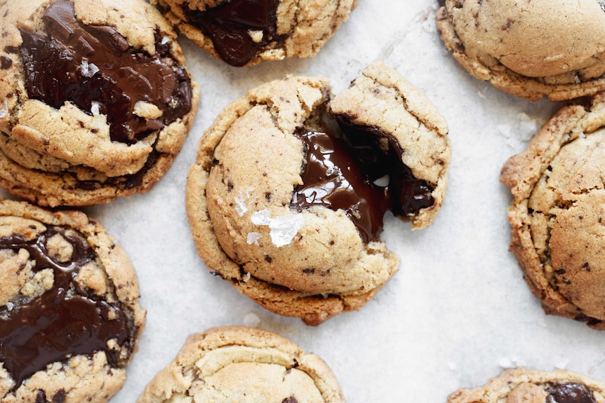 A close up of a freshly baked chocolate chip cookies with melted chocolate, illustrating our recipe.