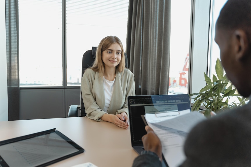 A young woman smiles and looks confident during job interview.