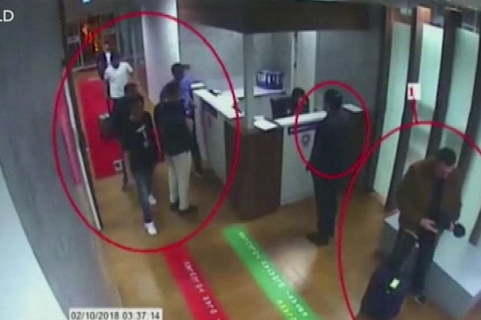 A CCTV screenshot of men with red circles around them