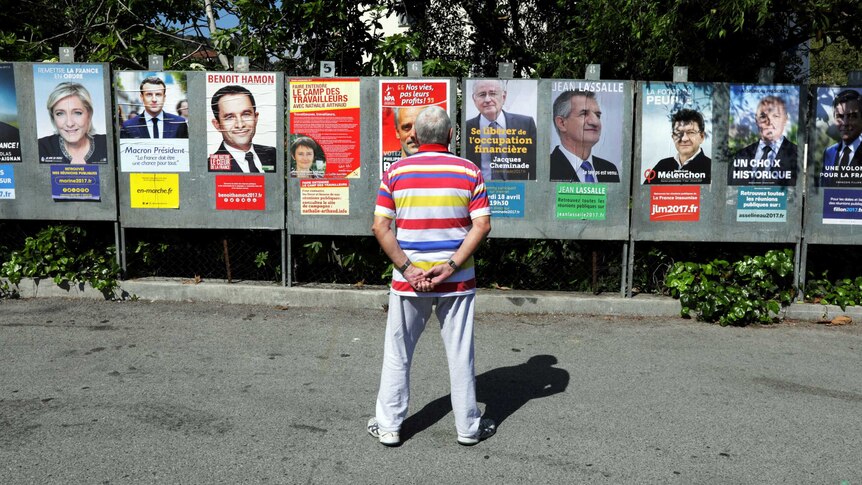 A man looks at campaign posters