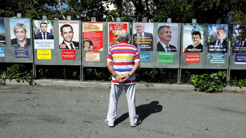 A man looks at campaign posters