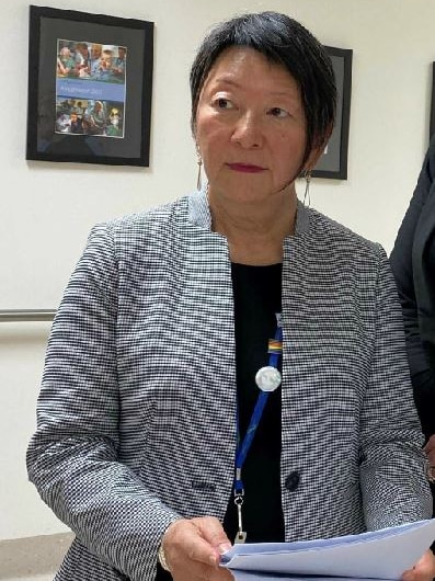 A woman with a black and white jacket and a black shirt.