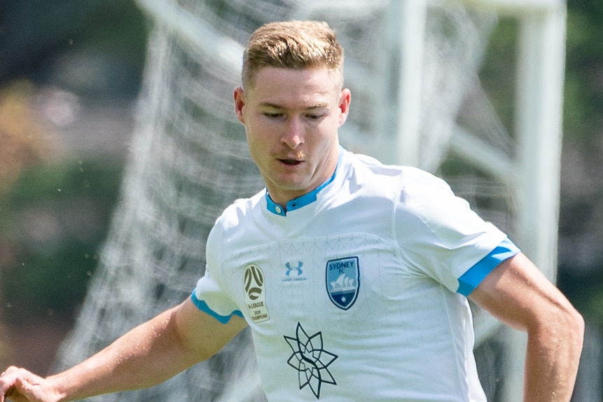 Harry van der Saag runs with the ball at his feet looking down.