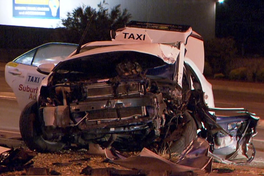 A white taxi with bad damage to its front and roof