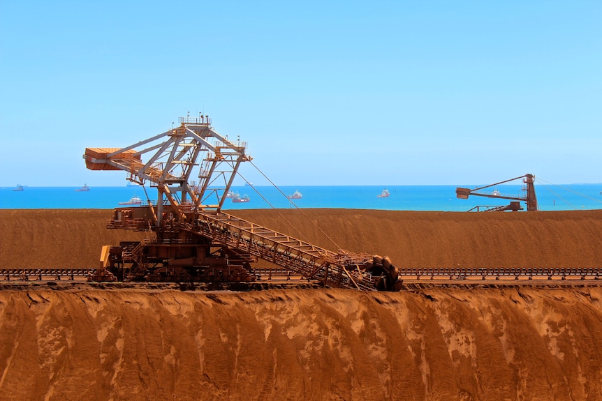 Iron ore stockpiles line up on a coastline