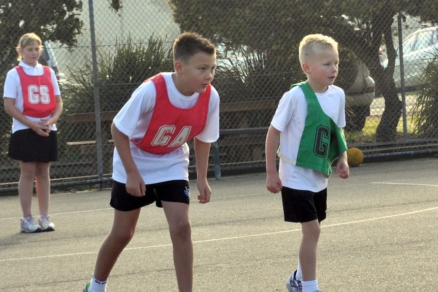 Zac's brother stands in a red GA bib and Zac next to him in a green GD bib 