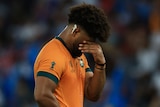 A Wallabies player with his hand over his face after losing to Fiji at the men's 2023 Rugby World Cup.