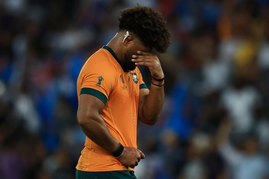 A Wallabies player with his hand over his face after losing to Fiji at the men's 2023 Rugby World Cup.