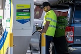 A man fills his car with petrol.