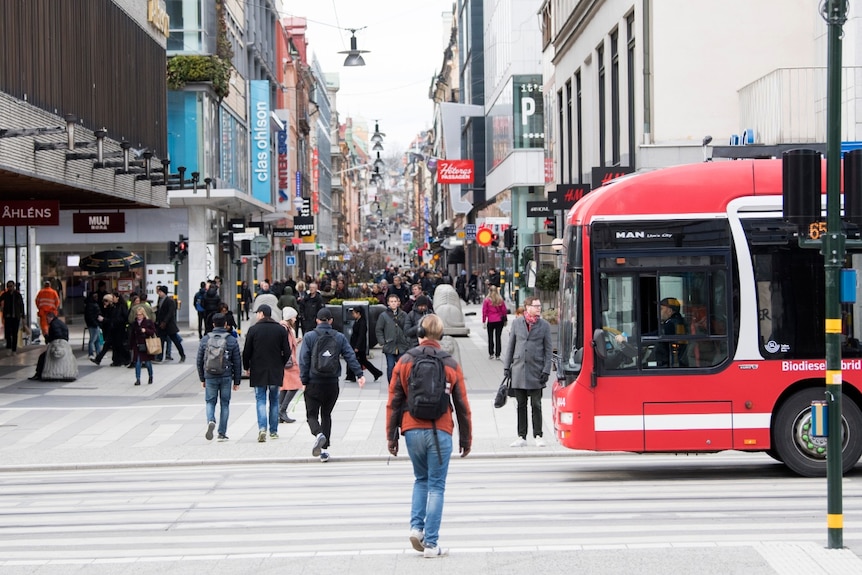 People walk through a busy shopping mall in Sweden during the coronavirus pandemic