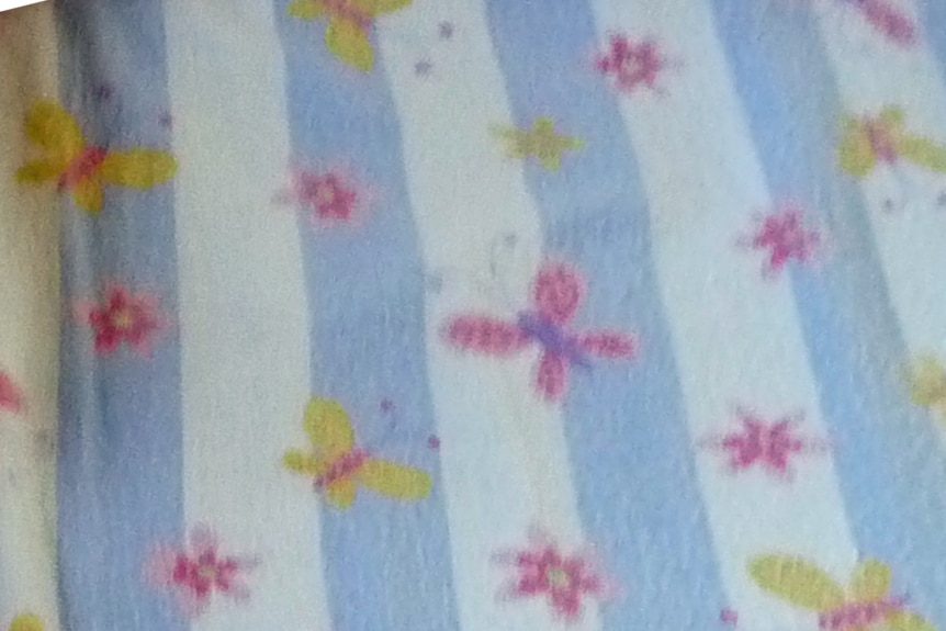 A fitted sheet with blue and white stripes and pink and yellow butterflies.