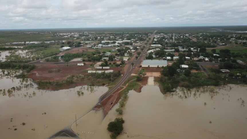 The land surrounding an outback town is under brown water, after flooding.