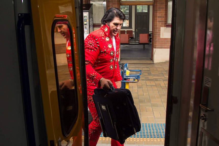 Elvis impersonator boarding train.