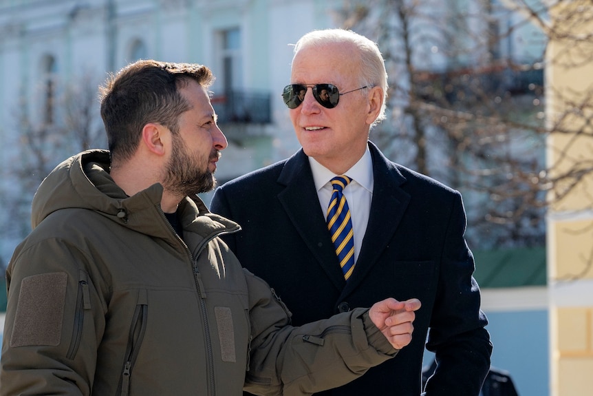 Mr Biden looks towards Mr Zelenskyy as the pair walk. 