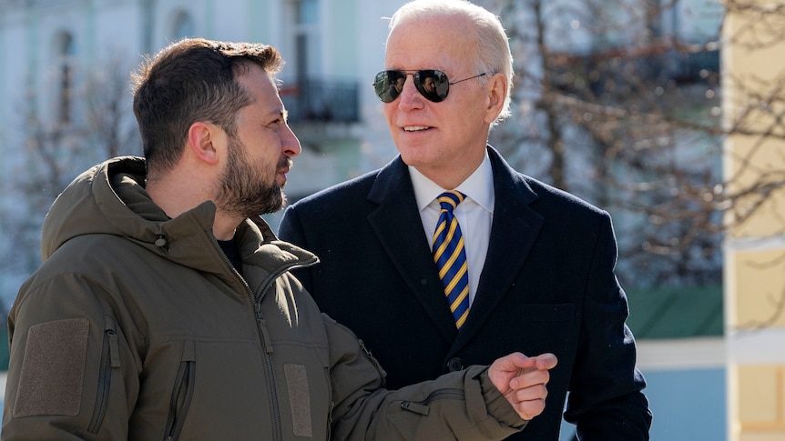 Mr Biden looks towards Mr Zelenskyy as the pair walk. 