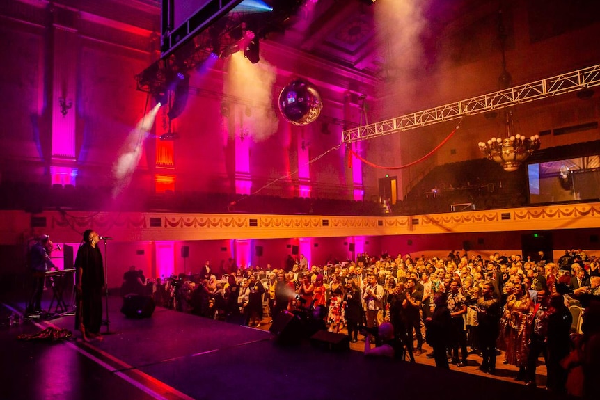 A crowd watches someone on stage