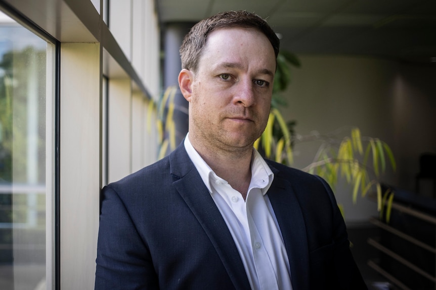 Matthew Pollock leans against a window.