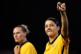 Australian Matildas star Sam Kerr smiles as she points her finger in the air during a game. 