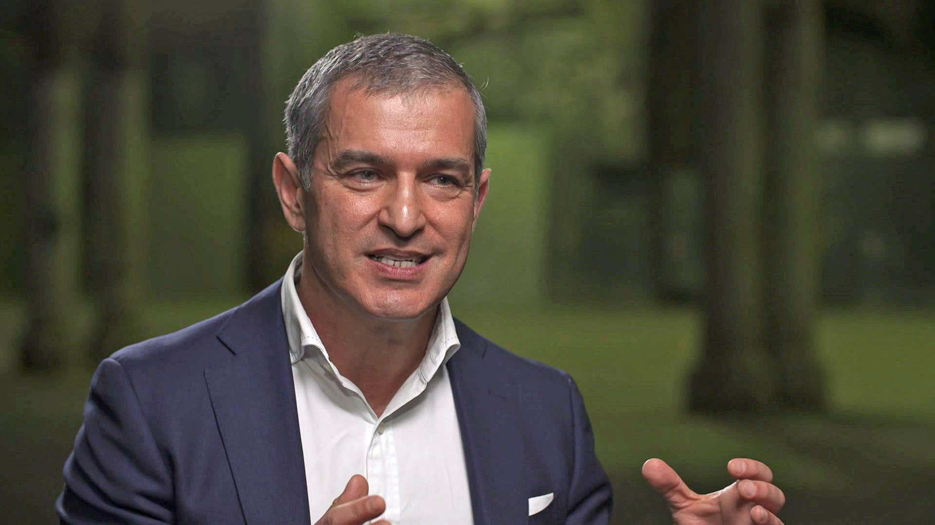 Paul Zahra wears a blue suit and white shirt.