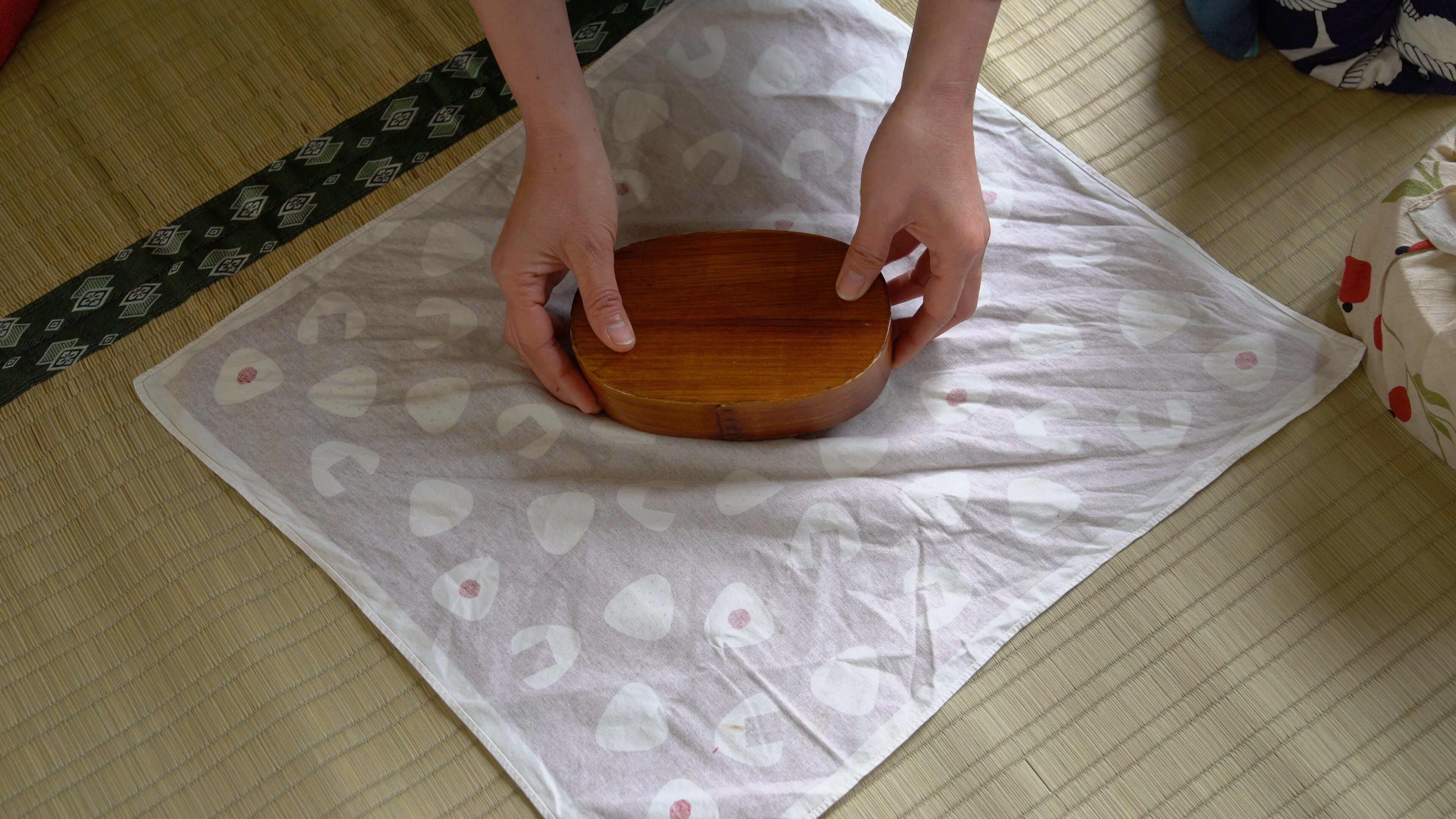 smal bento box placed in the middle of a square piece of fabric with the pattern face-down