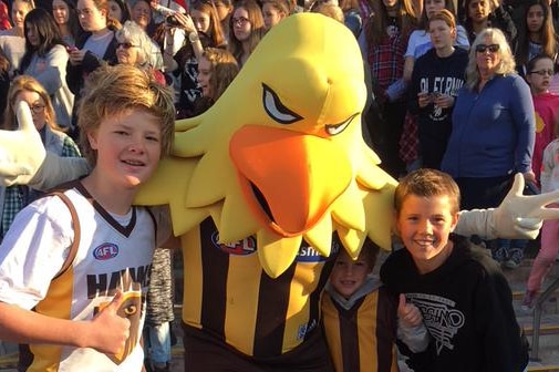 Hawks fans pose with Hawthorn mascot