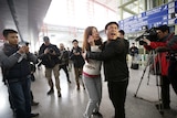A woman cries as she talks on her mobile phone at Beijing Capital International Airport