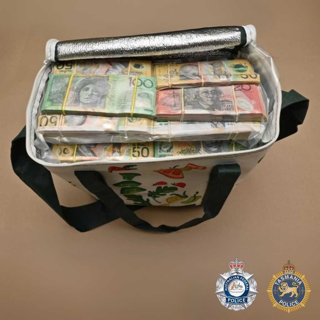 Cash inside a shopping bag on a desk.