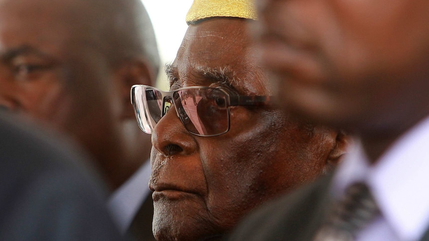 Robert Mugabe wears an academic gown standing among other officials at a graduation ceremony