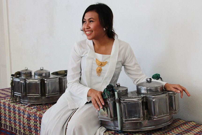 Indonesian singer Peni Candra Rini looks away from the camera and smiles.