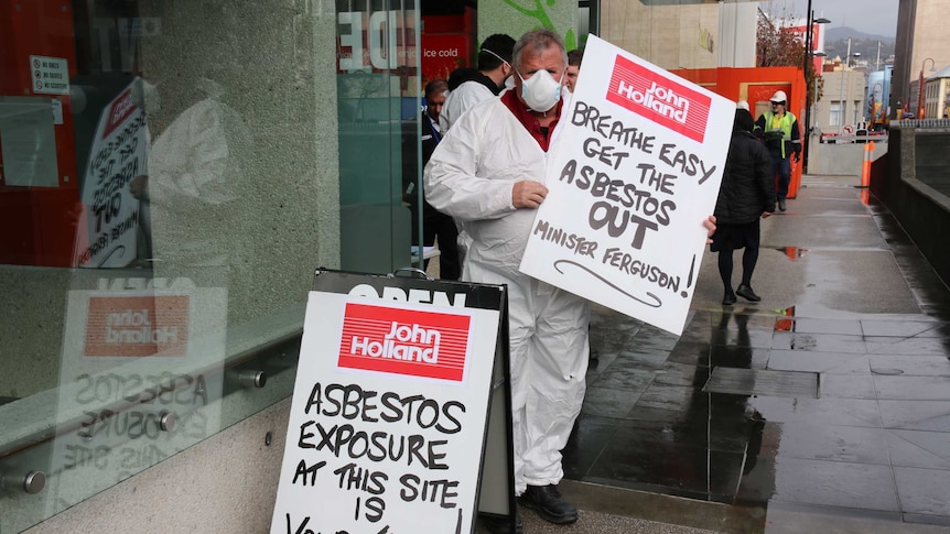 Kevin Harkins holds asbestos sign outside Royal Hobart Hospital