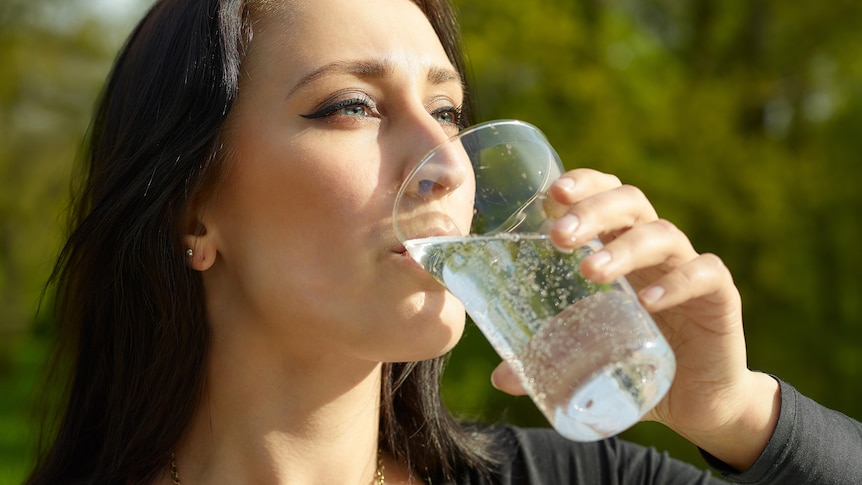 Woman drinking a glass of sparkling water