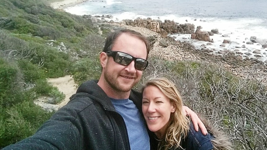 A couple pose for a selfie on a remote beach