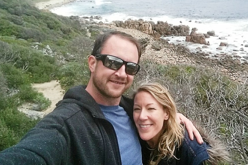 A couple pose for a selfie on a remote beach