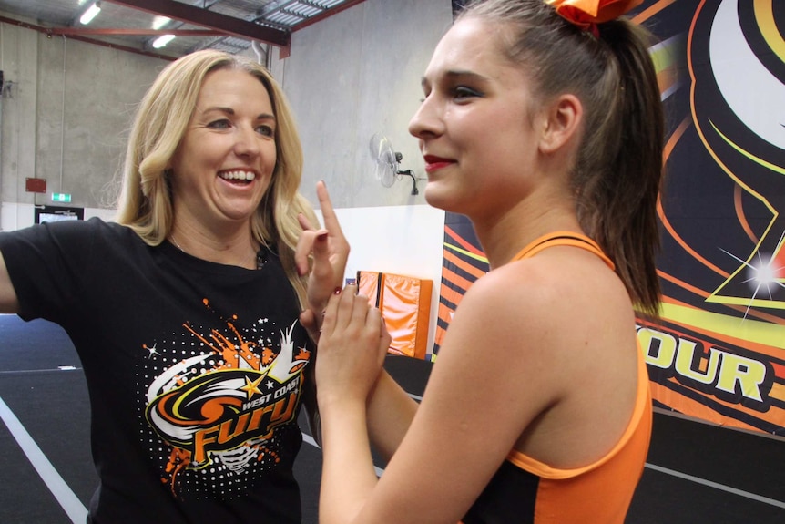 Vanessa smiles as she works with her cheerleading coach Peta Parker at West Coast Fury Cheerleading.