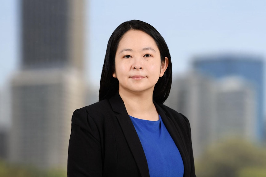 Chinese-Indonesian woman in business attire smiling to camera.