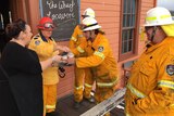 A woman serves firefighters coffees