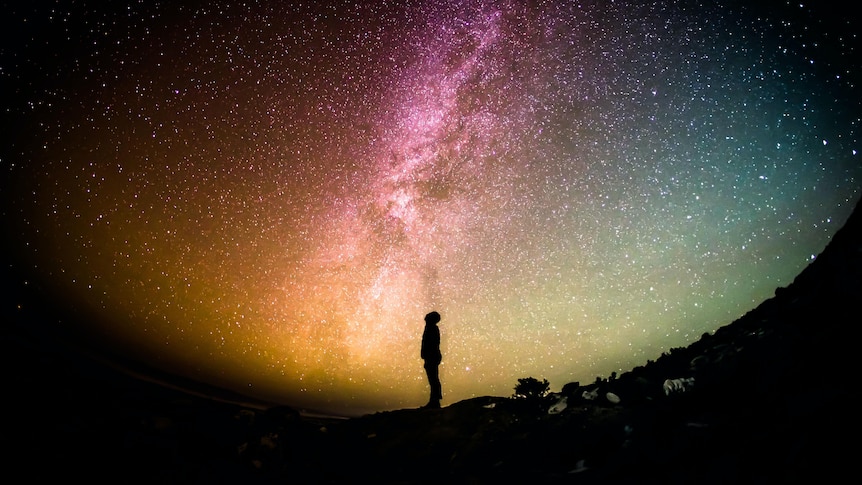 Silhouette of a man looking at stars in the sky