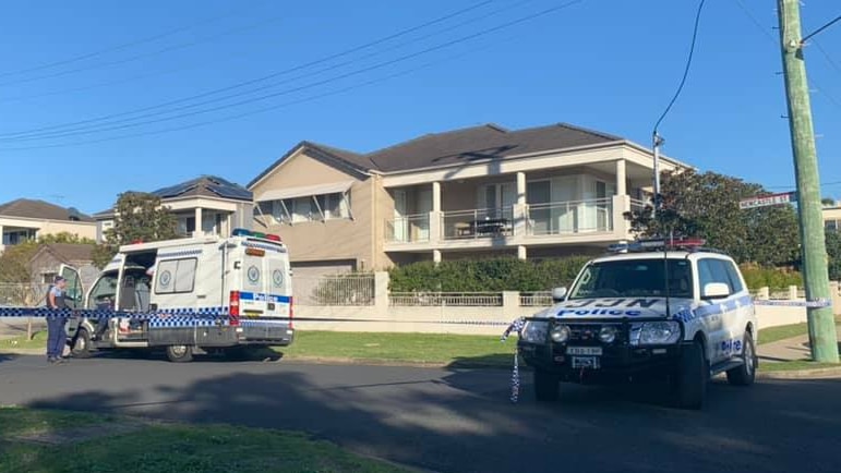 police vehicles and police tape outside a suburban house