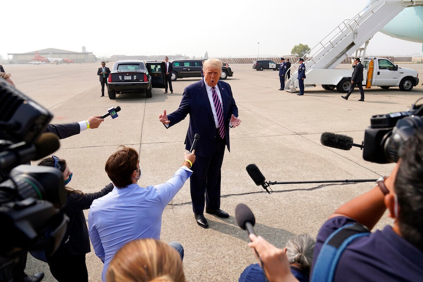 Donald Trump speaks to reporters on an airport flight apron.