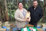 Melissa and Gary Ferguson stand in front of their property holding donations for a farmer relief drive.