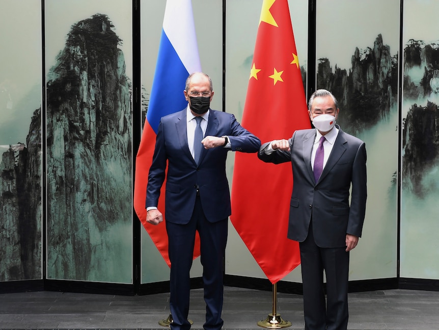 Russian Foreign Minister Sergey Lavrov and Wang Yi, both wearing black masks. 