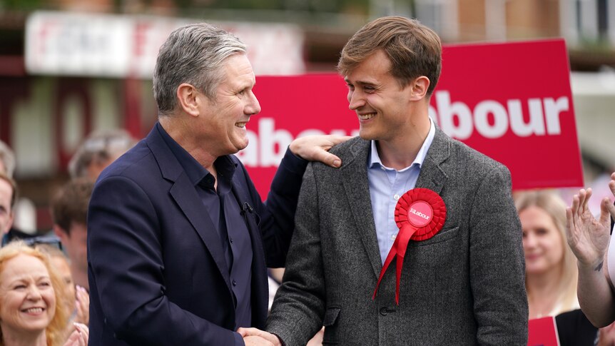 UK Labour leader Keir Starmer (left) smiles and shakes hand with new Labour MP Keir Mather