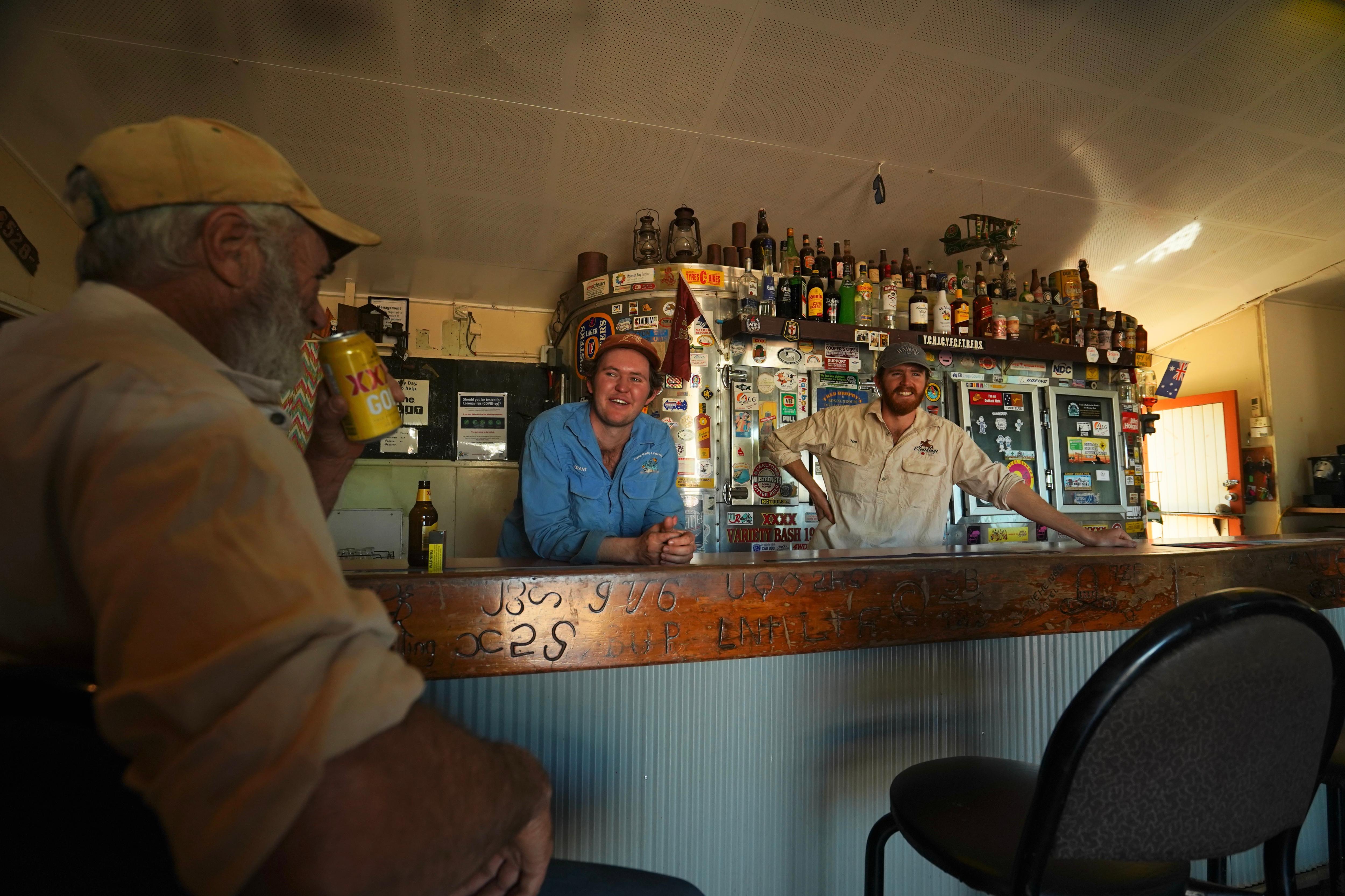 Two men in their 20s behind the bar of an outback pub