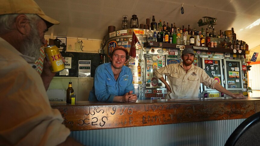 Two men in their 20s behind the bar of an outback pub