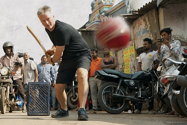 Steve Waugh plays cricket in a street in India.