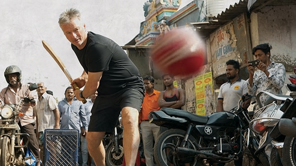 Steve Waugh plays cricket in a street in India.