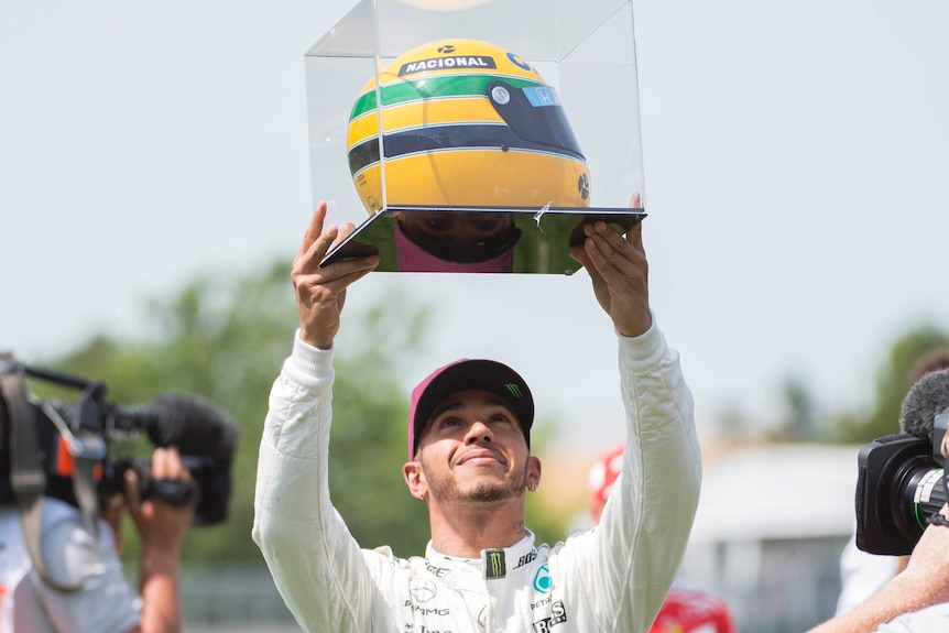 Lewis Hamilton presented with Ayrton Senna race-worn helmet