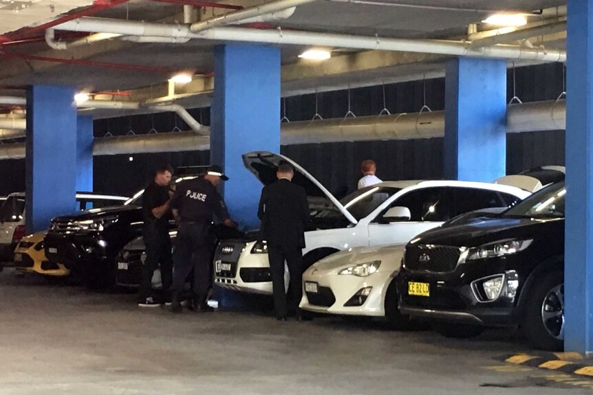 Police search a vehicle during raids at Sydney Olympic Park.