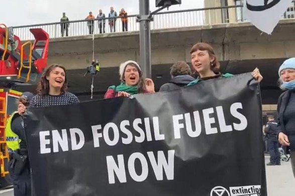 A group of people holding a sign reading 'End fossil fuels now'