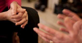 Hands of therapist and client during counselling session.